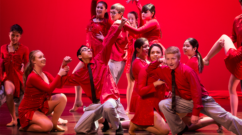 Dancers performing on stage in red
